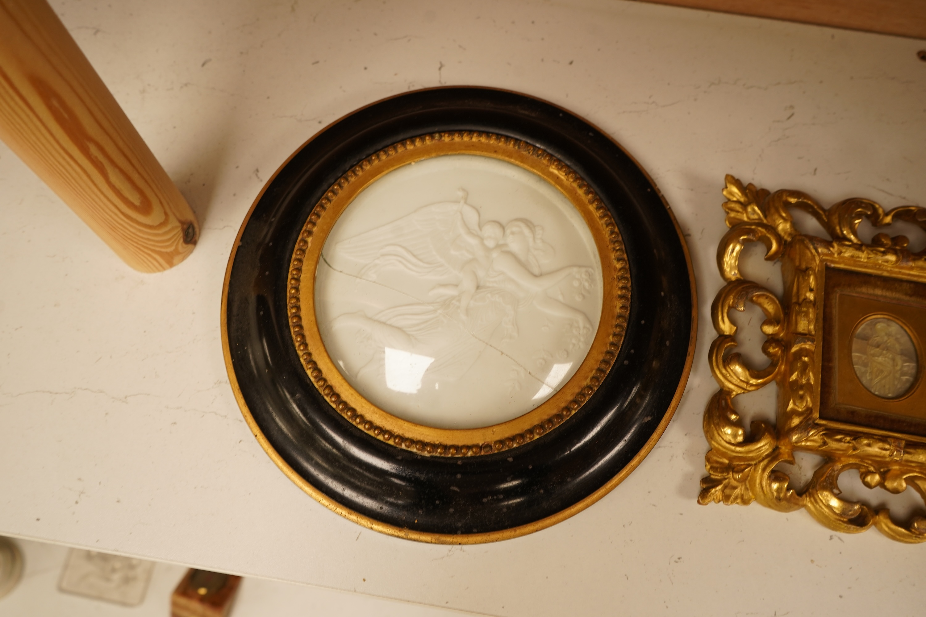 A late 19th century mother of pearl plaque of a saint, housed in a gilt wood florentine frame, together with a pair of Copenhagen biscuit porcelain plaques of Night and Day after Thorvaldsen, in convex frames